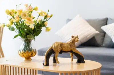 a figurine on a table next to a vase of flowers at Laguna Beachside Residents in Phuket