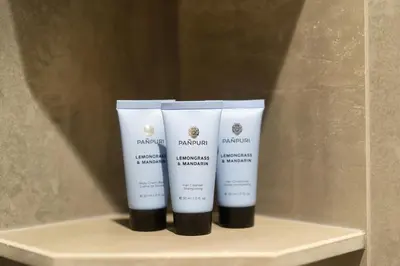 a shelf with three bottles of sunscreen on it at Laguna Beachside Residents in Phuket
