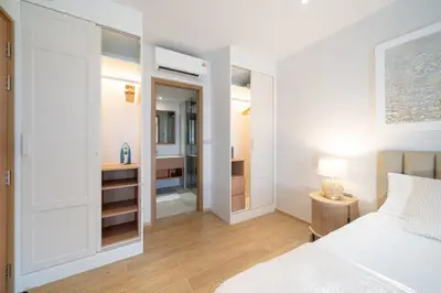 a bedroom with a white bed and a mirror at Laguna Beachside Residents in Phuket