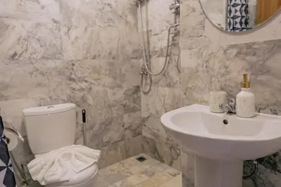 a bathroom with a white toilet and a sink at 1 BR studio 777 Beach Condotel in Mai Khao Beach
