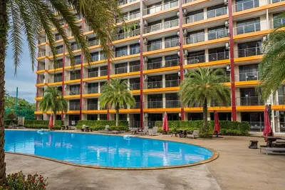 a hotel with a swimming pool in front of a building at 1 BR studio 777 Beach Condotel in Mai Khao Beach