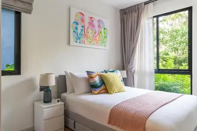 a white bedroom with a bed with a window at Title Halo 1st Floor Naiyang Pool Gym 2BR in Nai Yang Beach