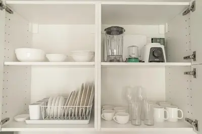 a white cabinet filled with dishes and other kitchen items at Title Halo 1st Floor Naiyang Pool Gym 2BR in Nai Yang Beach