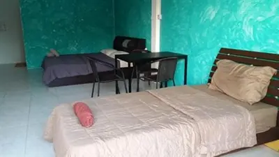 a bedroom with a bed and a table and a desk at Da Puccio Rawai Guesthouse in Rawai Beach