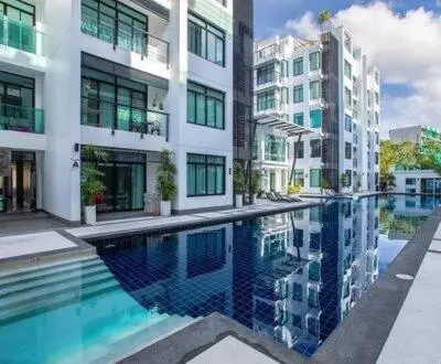 a building with a swimming pool in front of a building at Modern 2-Bedroom Condo in Kamala Near the beach in Kamala Beach