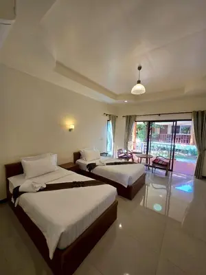a hotel room with two beds and a balcony at OYA International Resort Phuket \u666e\u5409\u5c9b\u6b27\u96c5\u56fd\u9645\u5ea6\u5047\u9152\u5e97 in Phuket Town