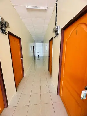 an empty hallway in a hospital with orange doors at Navy Guesthouse in Ban Laem Sai