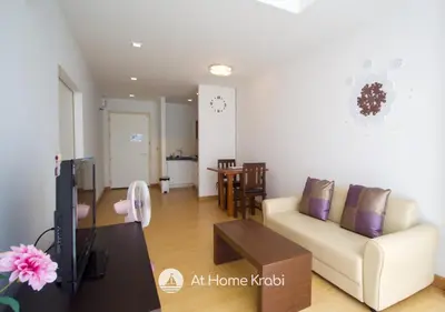 a living room with a couch and a table at At Sea Condotel in Klong Muang Beach