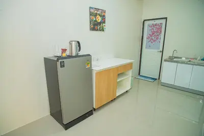 a kitchen with a refrigerator and a counter in it at Songbird Suites - Deluxe Twin Suite and Scooter in Ao Nang Beach