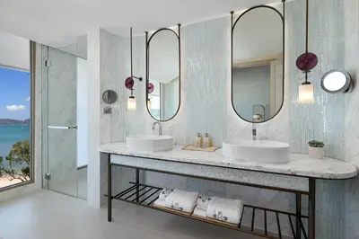 a bathroom with two sinks and two mirrors at Veranda Resort Phuket, Autograph Collection in Panwa Beach
