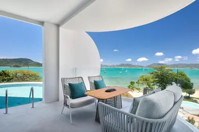 a patio with a table and chairs and a view of the ocean at Veranda Resort Phuket, Autograph Collection in Panwa Beach