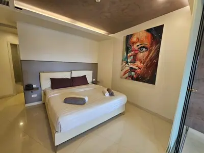 a bedroom with a bed with a painting on the wall at C162 Sea View 8 Minuets to Patong Karon Butter Fly in Karon Beach