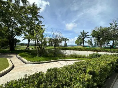 a walkway in a park with trees and grass at 2 BD Skypark Condo with Terrace in Laguna Phuket