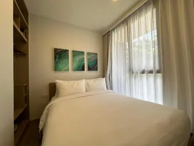 a bedroom with a large white bed and a window at 2 BD Skypark Condo with Terrace in Laguna Phuket