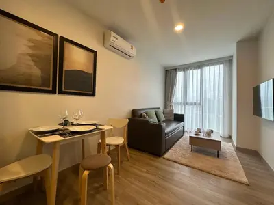 a living room with a couch and a table with chairs at 1 BD Laguna Skypark Golf Course View in Phuket