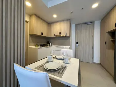 a kitchen with a table with plates and wine glasses at 2 BD Skypark Condo in Laguna Phuket