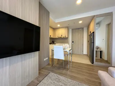 a living room with a large flat screen tv on a wall at 2 BD Skypark Condo in Laguna Phuket