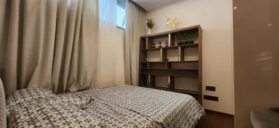 a bedroom with a bed and a book shelf at Angsana Beachfront Residences in Phuket
