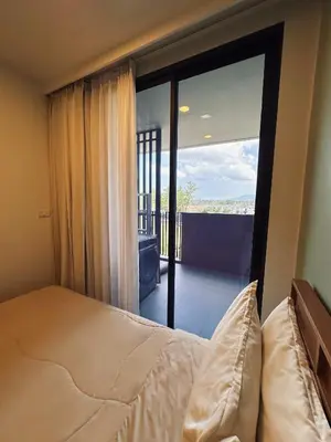 a bedroom with a bed and a view of a balcony at 2 BD Laguna Skypark Condo in Phuket