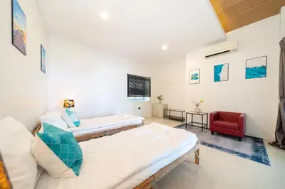 a living room with two beds and a red chair at Patong Cliff Villa Phuket 12 bedroom in Patong Beach