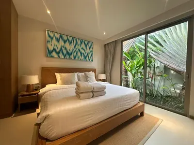 a bedroom with a bed and a large window at Trichada Sky 3BD in Phuket
