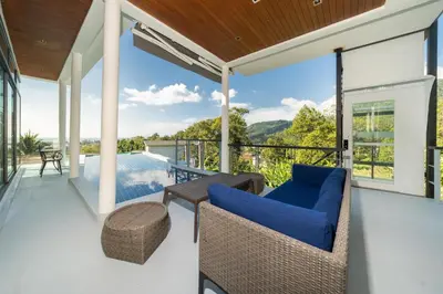an outdoor patio with a view of the mountains at Amor Primero - sea view pool villa with maid in Kamala Beach