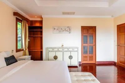 a bedroom with a large white bed and a door at Luxurious Phuket Escape - Lakewood Hills in Layan Beach