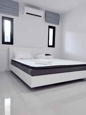 a white bedroom with a large bed in it at 150 square meters 3BR with parking townhouse near golf course, UWC school, Nayang Beach, airport in Ban Muang Mai (1)