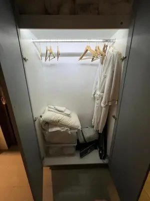 a walk in closet with white clothes and hangers at Palmyrah Surin Beach Residence in Surin Beach