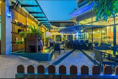 a restaurant with tables and chairs and an umbrella at Chalong Miracle Lakeview in Chalong