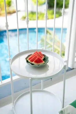 a slice of watermelon on a white plate on a table at Title Halo Romantic Suite Pool View Gym in Nai Yang Beach