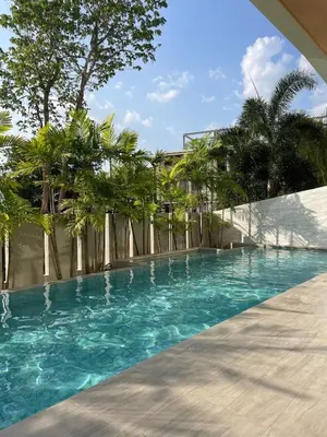 a swimming pool with blue water and palm trees at Prime Location46 sqm Room, King-Size Bed in Ao Nang Beach