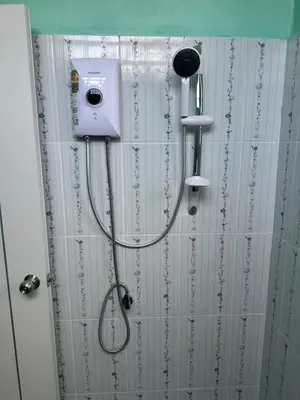 a shower with a shower head and a shower curtain at Boonyawat Apartment in Kata Beach