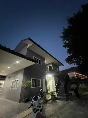 a house with a motorcycle parked in front of it at Boonyawat Apartment in Kata Beach