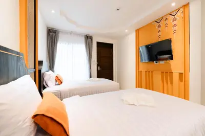 a hotel room with two beds and a flat screen tv at Noppharat Krabi Resort in Ao Nang Beach
