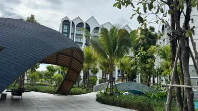 a building with a wooden archway in a park with palm trees at JU1 NEW Halo Nayang Руб ВАТСАП669З582I976 in Nai Yang Beach