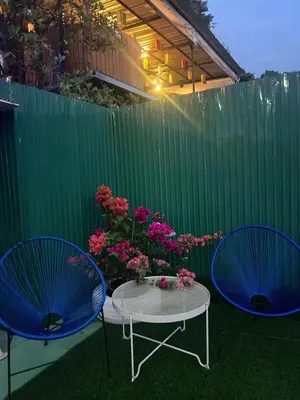 a patio with two blue chairs and a table with flowers at Camping Phuket 88 in Kathu