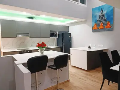 a kitchen with a white counter and black chairs at Sawansa 34B 475m2 Luxury Sea view pool near beach in Patong Beach