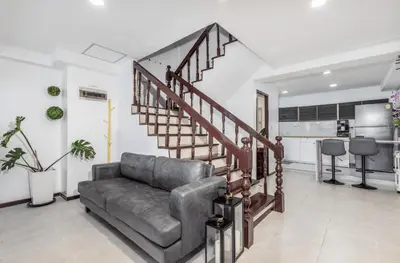 a living room with a couch and a spiral staircase at Sawansa 20 3BR 300m2 Modern Seaview house near Beach in Patong Beach
