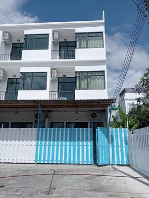 a white building with a blue fence in front of it at Sawadee622,Naiharn & Rawai beach Phuket in Rawai Beach
