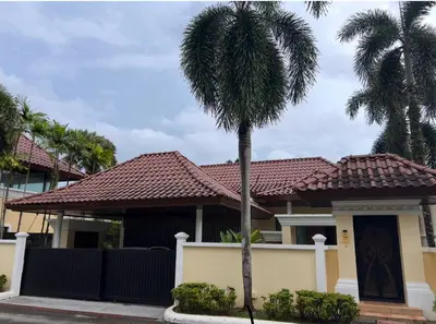 a house with a palm tree in front of it at Ocean Villa Bang Tao Phuket in Ban Thalat Choeng Thale