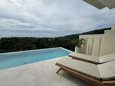 a swimming pool sitting on a patio with a chair at MANDARIN villa, Naithon beach, Phuket in Phuket