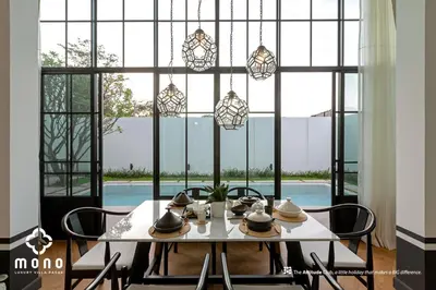 a dining room with a table and chairs and a large window at Skyframe pool villa near Bangtao beach, Bluetree, Thalang in Ban Pak Lak