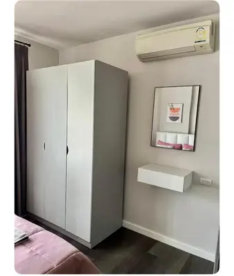 a bedroom with a white cabinet and a mirror at Dcondo kuku resort in Ban Phlu Yai