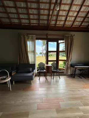 a living room with a couch and chairs and windows at Rawi Seaside Cottage, Ko Yao Noi in Ban Laem Sai