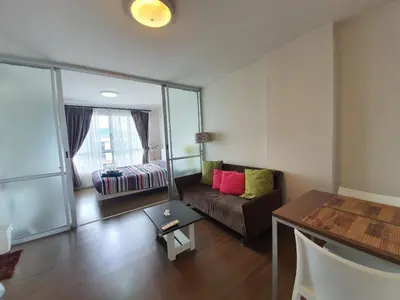 a living room with a couch and a table at Dcondo Creek Poolview by Lachambre Phuket in Phuket Town