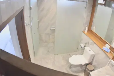a bathroom with a white toilet and a shower at Blue Canyon Country Club Golf Course Maikhao in Phuket