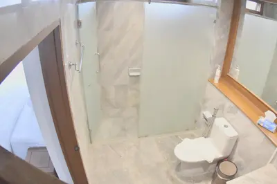 a bathroom with a white toilet and a shower at Blue Canyon Country Club Golf Course Maikhao in Phuket