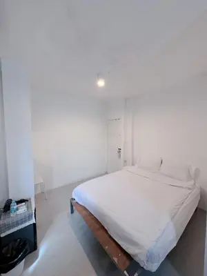 a white bed in a white room with a bed frame at XX BAO Patong Beach Phuket II เบา ป่าตอง บีช ภูเก็ต in Patong Beach
