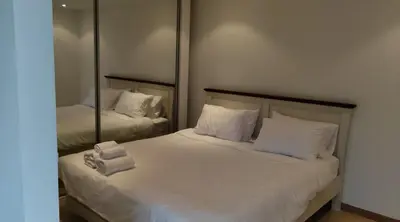 a bedroom with two beds with mirrors and towels at Thebirdhouse Patong Phuket 301 in Patong Beach